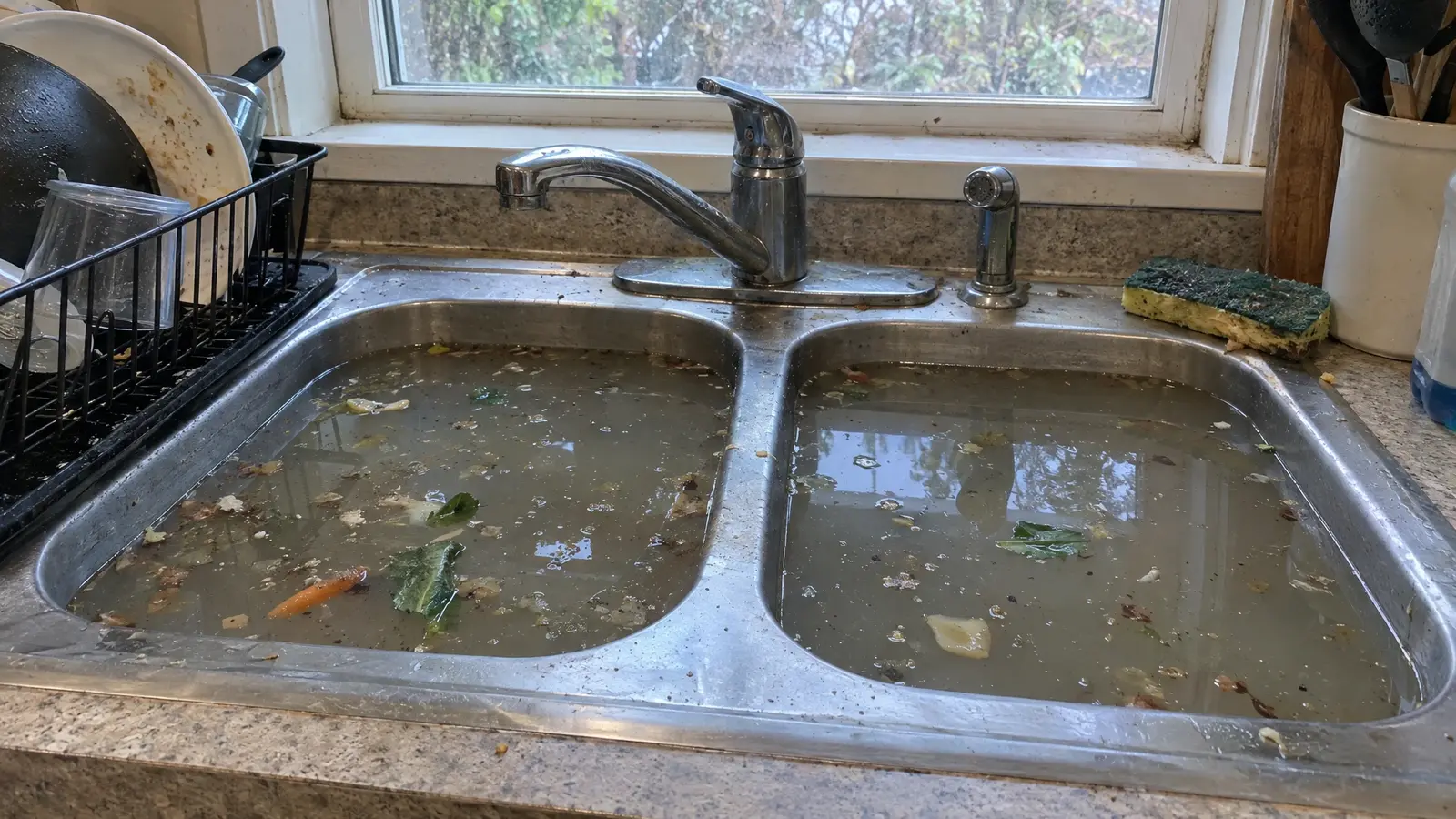 Before: a kitchen sink with murky standing water and floating debris